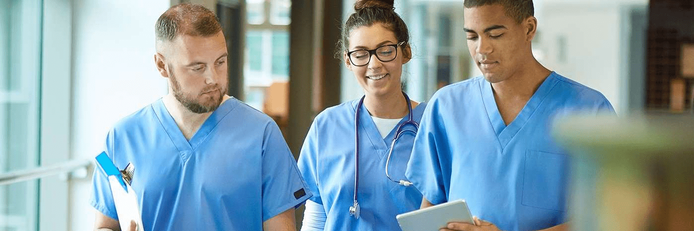 teams-three-healthcare-professionals-walking-in-a-medical-building-and-looking-at-a-tablet-device